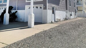 A two-story house with a balcony, a garage, and a driveway. - Beautiful 4-bedroom, beach block home in Sea Isle City!  (Sea Isle City)