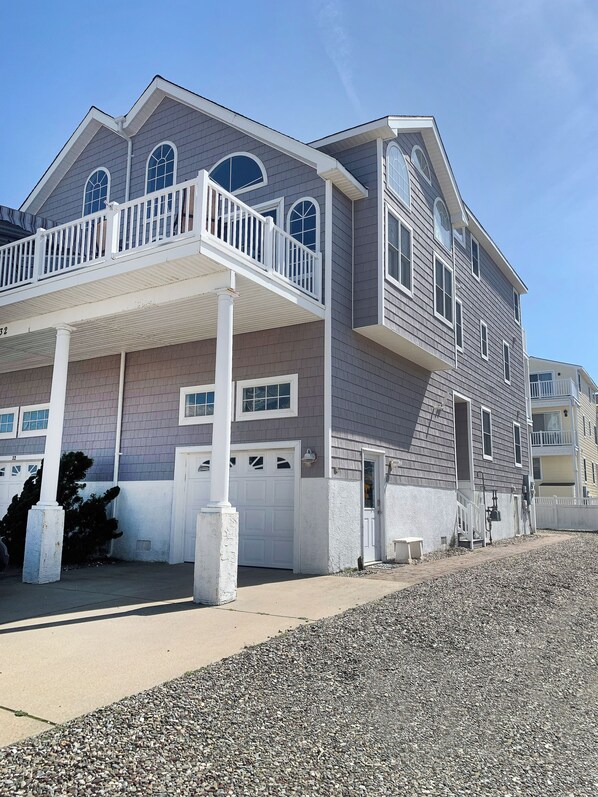 A two-story house with a balcony, a garage, and a driveway.