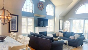 A spacious living room with a fireplace, comfortable seating, and large windows. - Beautiful 4-bedroom, beach block home in Sea Isle City!  (Sea Isle City)