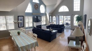 A spacious living room with a dining area, large windows, and a view of the outside. - Beautiful 4-bedroom, beach block home in Sea Isle City!  (Sea Isle City)
