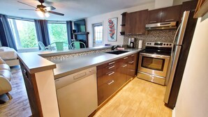 A modern kitchen with a dishwasher, oven, and stainless steel appliances. - Open Plan Living Area, 2 Q Beds, Full Kitchen, Walk to Trails, Portable AC (Fernie)