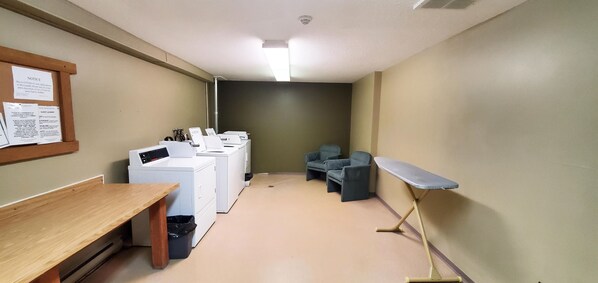 A laundry room with a table, chairs, and a drying rack.