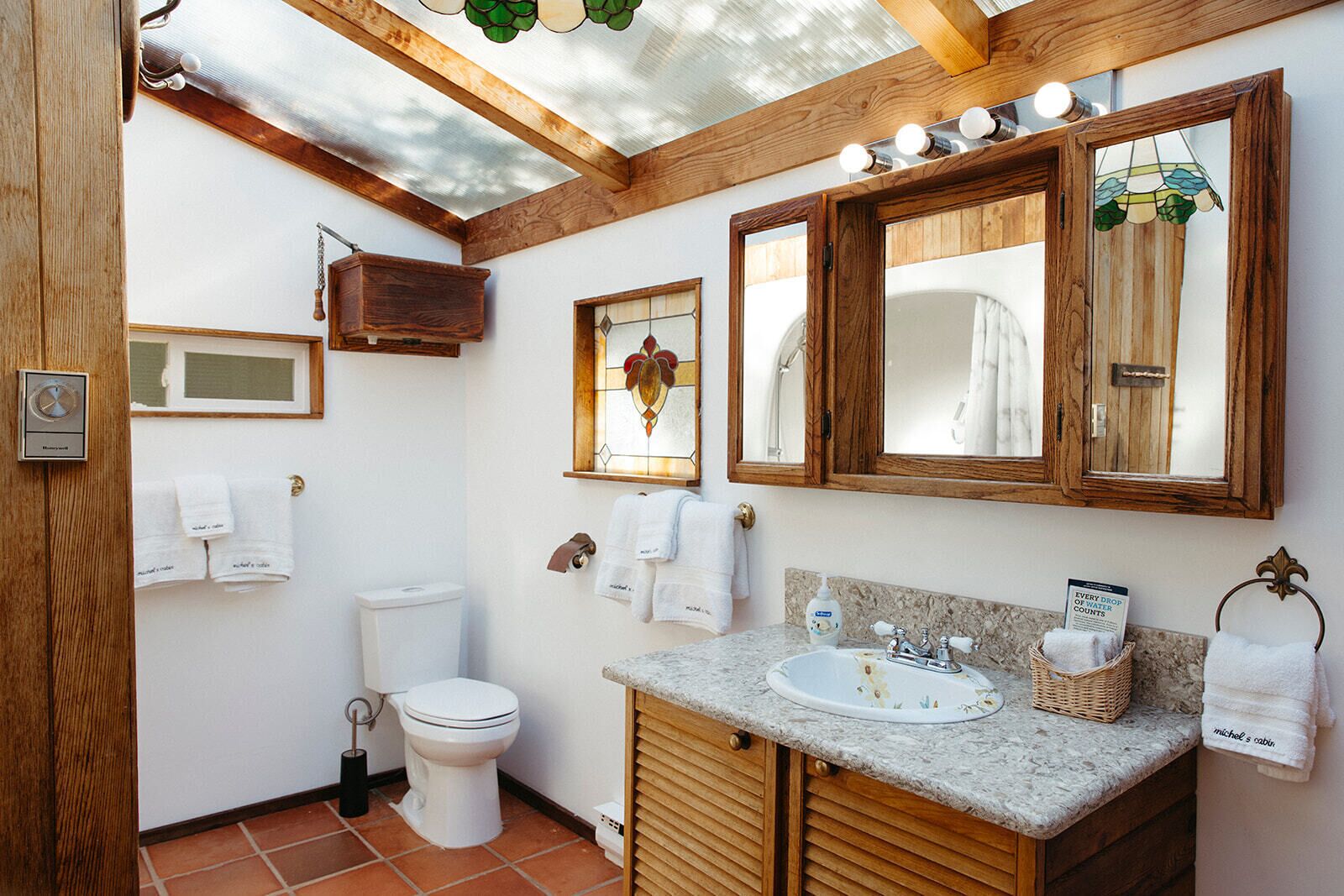 Une salle de bain avec des toilettes, un lavabo et des meubles en bois.