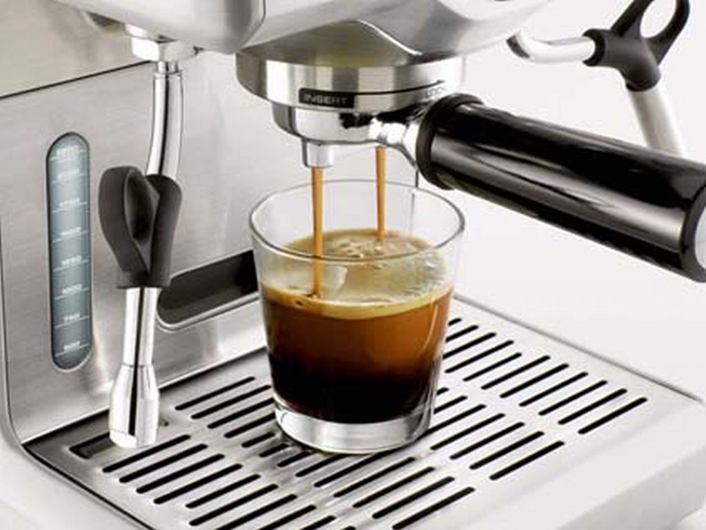 Une machine à café qui verse du café dans un verre.