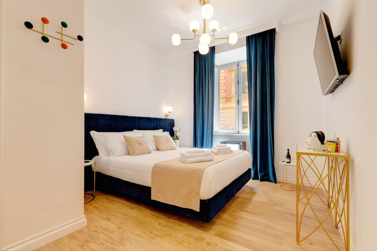 A neatly arranged bedroom with a bed, bedside table, and a TV mounted on the wall.