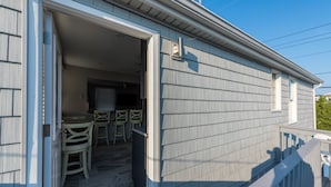 A house with a covered porch, a dining area with chairs and a table, and a small window. - 2026 LAVALLETTE NEW Kitchen and Bathroom, Outdoor Shower & BEACH BADGES INCLUDED (Lavallette)