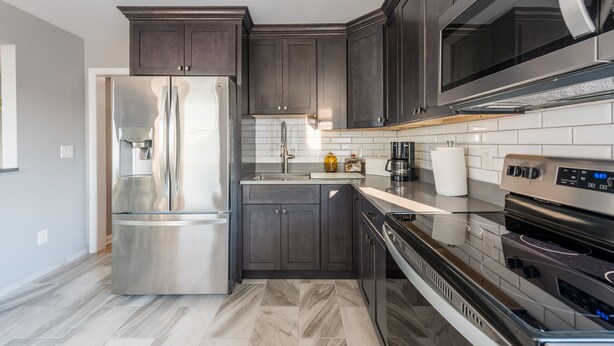 A modern kitchen with dark cabinetry, stainless steel appliances, and a tiled backsplash. - 2026 LAVALLETTE NEW Kitchen and Bathroom, Outdoor Shower & BEACH BADGES INCLUDED (Lavallette)