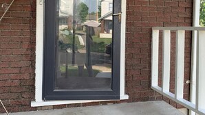 A black-framed glass door with a mailbox labeled "1017" on the brick wall.
