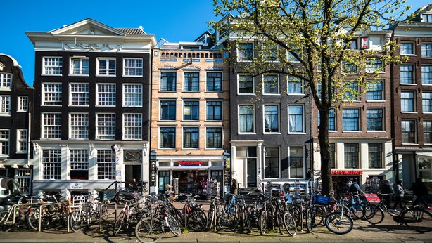A row of historic buildings with a row of bicycles parked in front. - Dutch House (Amsterdam)