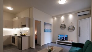 Una sala moderna con sofás verdes, una mesa de centro y un televisor.