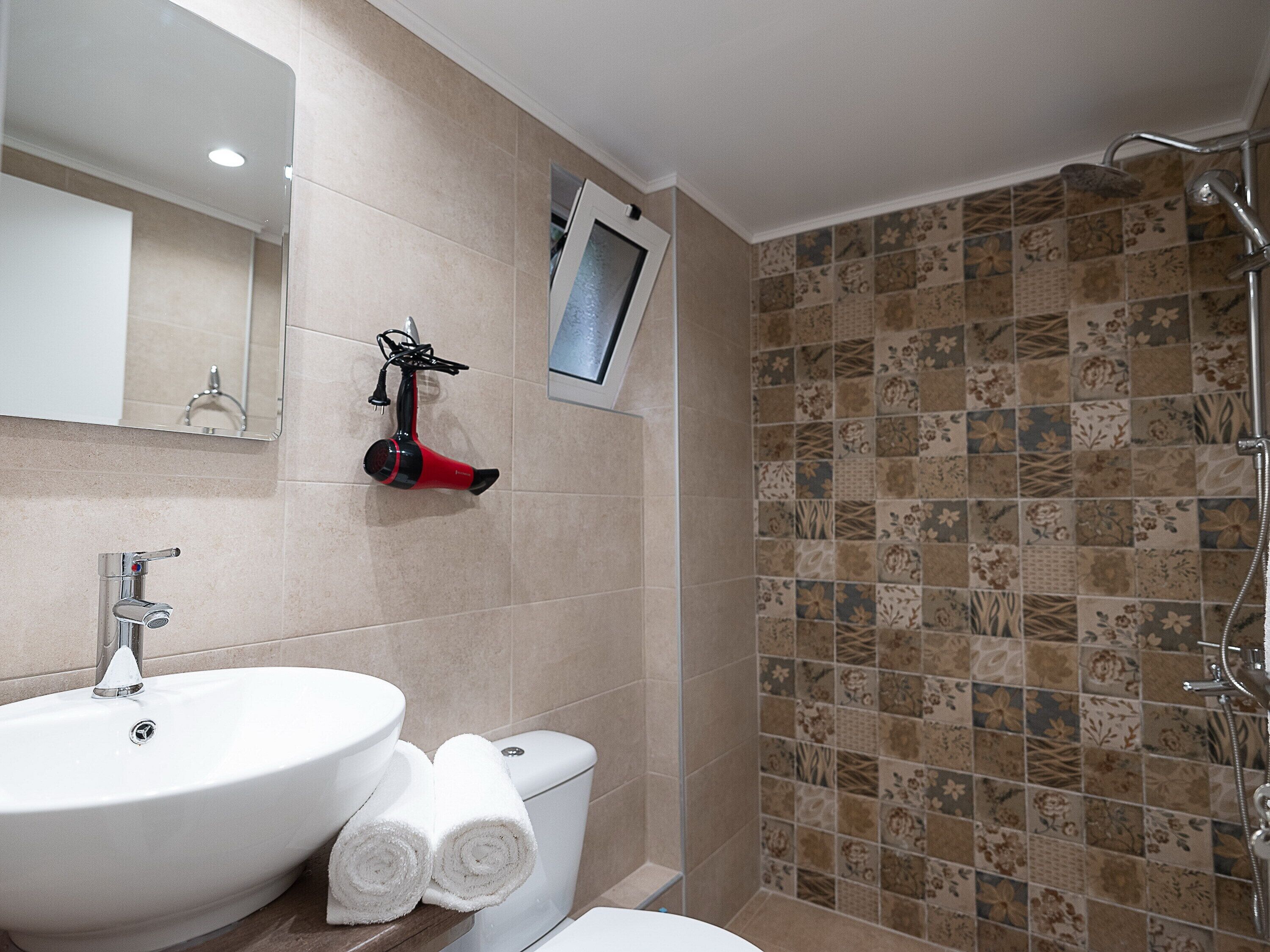 Un baño con lavabo, inodoro y ducha.