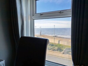 A room with a view of the beach and ocean through a window. - Seahawk Holiday Apartments (Thornton-Cleveleys)