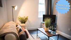 Un salon confortable avec un canapé, une table basse et un téléviseur.