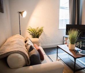 Een woonkamer met een bank, een salontafel en een televisie.
