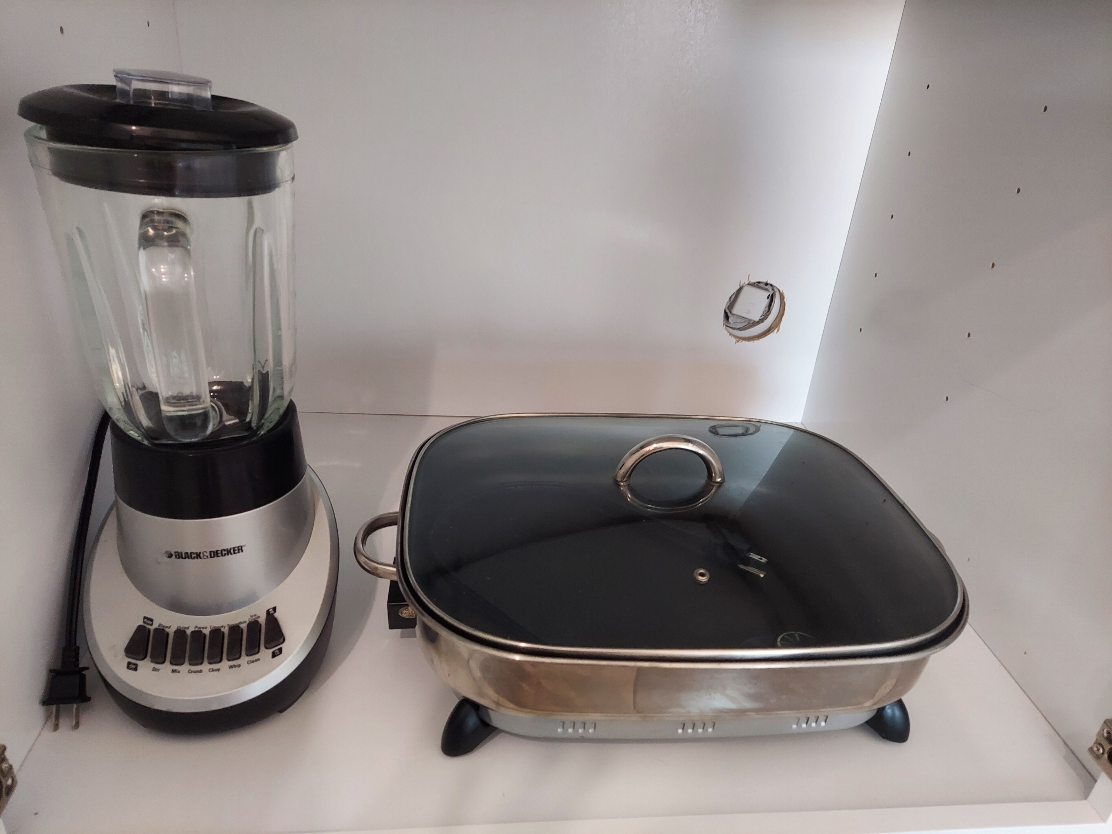 A kitchen with a blender and a slow cooker on the counter.