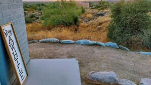 Paisatge desèrtic amb un senyal que diu "Stay AWAKE" a la paret exterior d'un edifici.