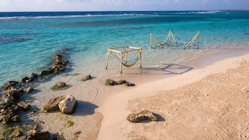 Playa en los alrededores, playa de arena blanca y toallas de playa 