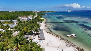 A coastal area with a beach, a pier, and a lighthouse. - Eco Cabañas BlueKay (Mahahual)