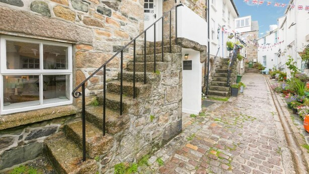 Un bâtiment en pierre avec un escalier menant à une porte portant le numéro « 15 ».