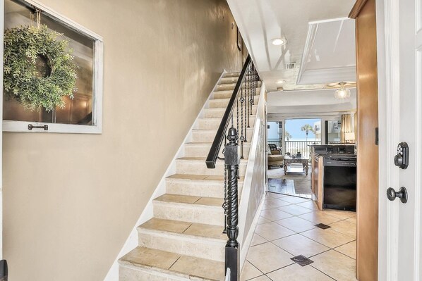 A staircase leading to a living area with a kitchen visible in the background.
