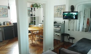 Eine moderne Küche mit Essbereich, einem Flachbildfernseher und einem Spiegel.