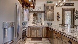 A kitchen with wooden cabinets, a marble countertop, stainless steel appliances, and a farmhouse-style ceiling. - Cozy Brian Head Cabin Near Ski Resorts, Bike Trails, and National Forests (Brian Head)