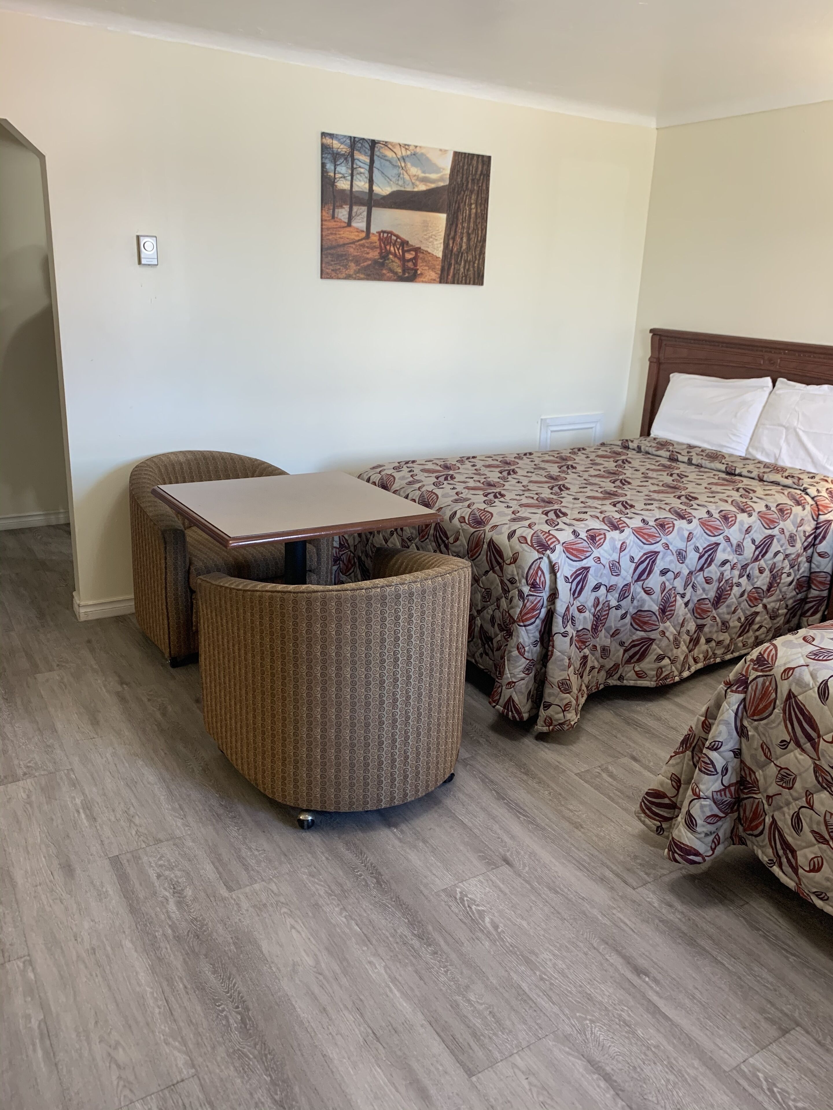 A room with a bed, a small table, and a chair.