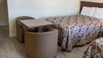 Una habitación con una cama, una mesita y una silla.