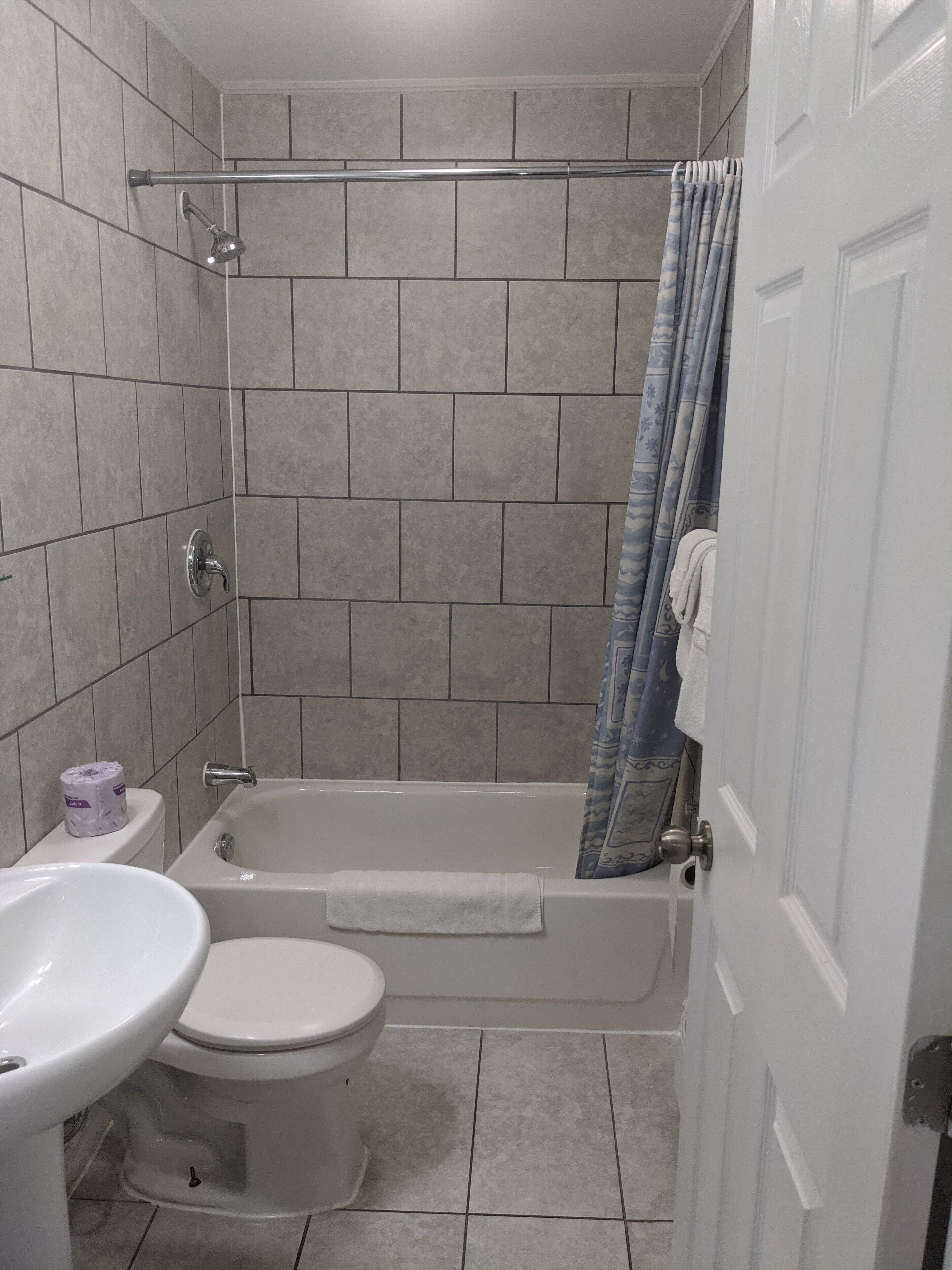 A bathroom with a bathtub, toilet, and sink.