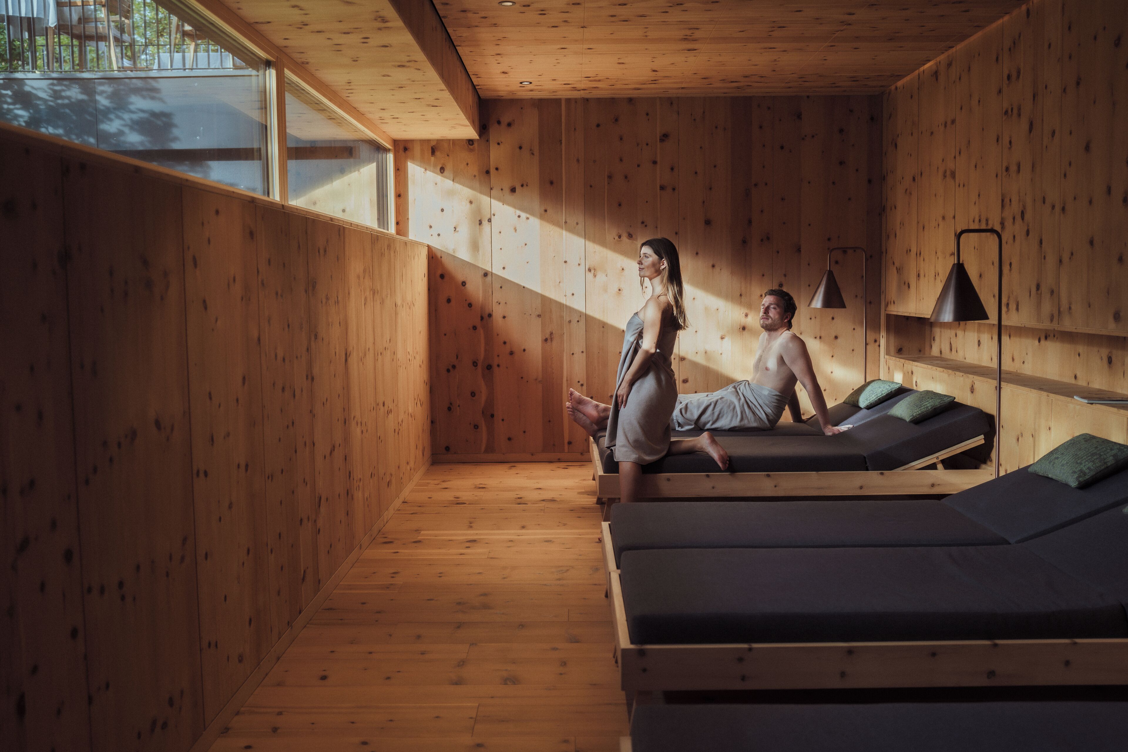 Une pièce en bois avec des tables de massage et une grande fenêtre.
