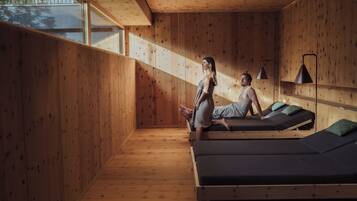 Une pièce en bois avec des tables de massage et une grande fenêtre.