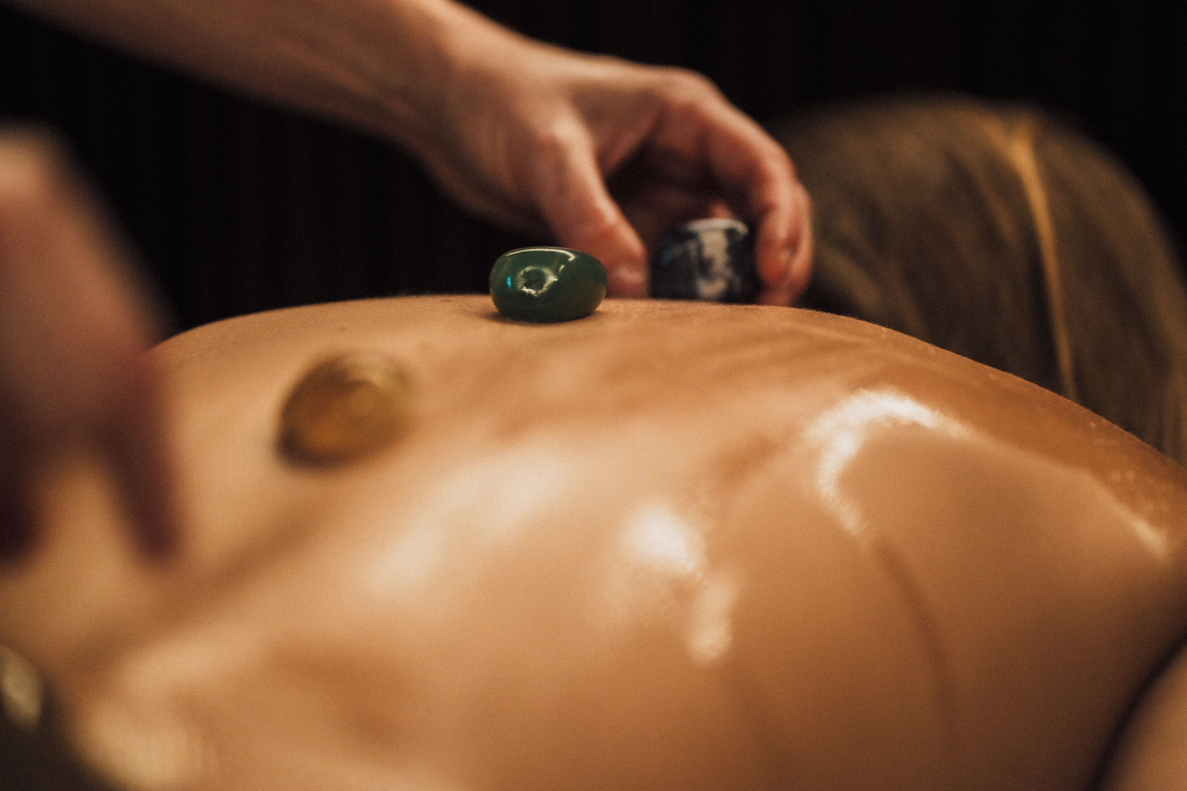 A close-up of a massage therapy session with a focus on a person's back and hands.
