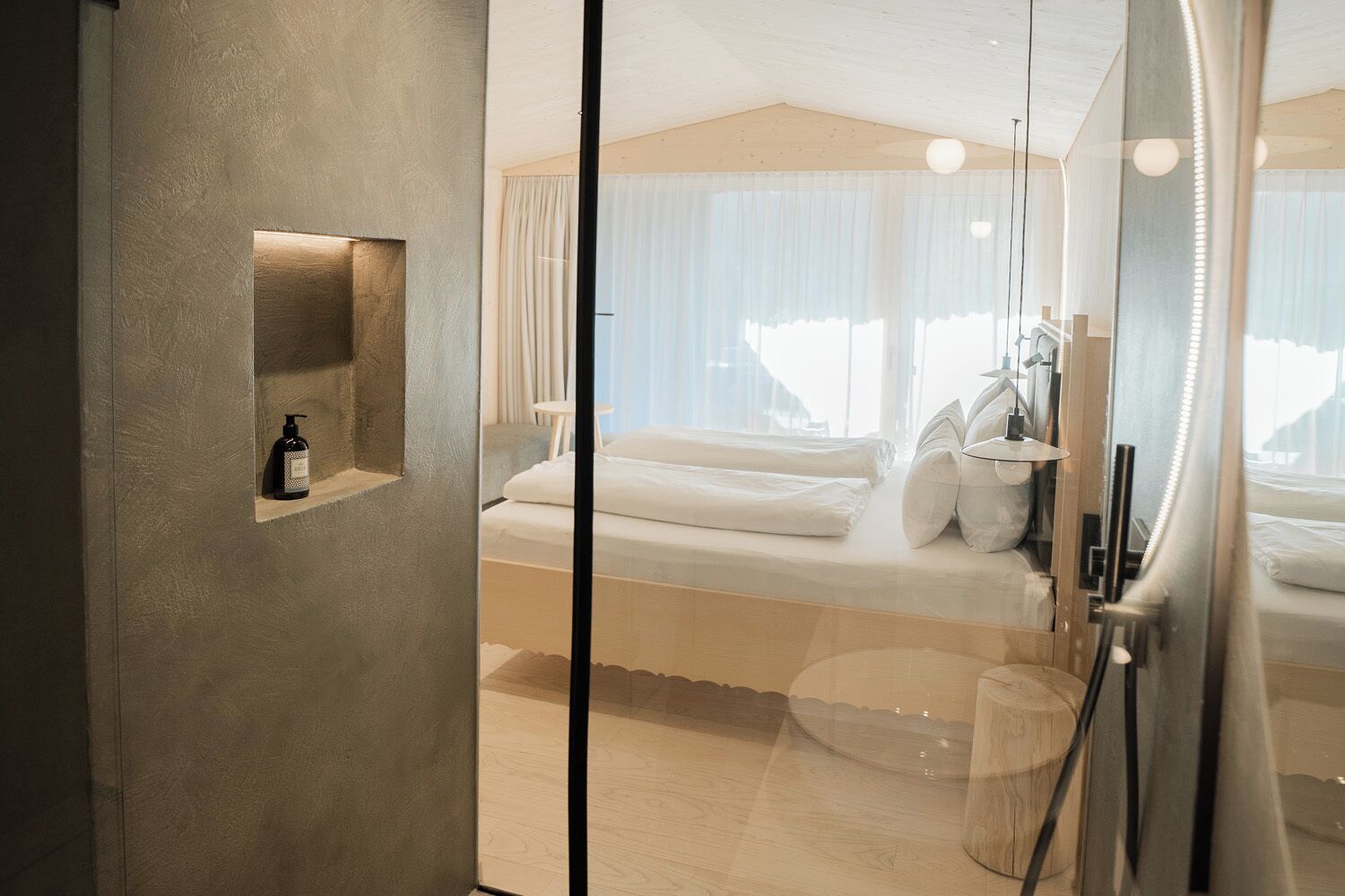 Une chambre d’hôtel moderne avec un grand lit, une table de chevet et un miroir.