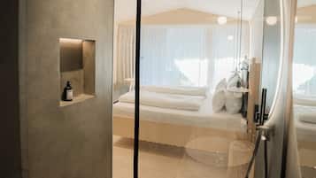 Une chambre d’hôtel moderne avec un grand lit, une table de chevet et un miroir.
