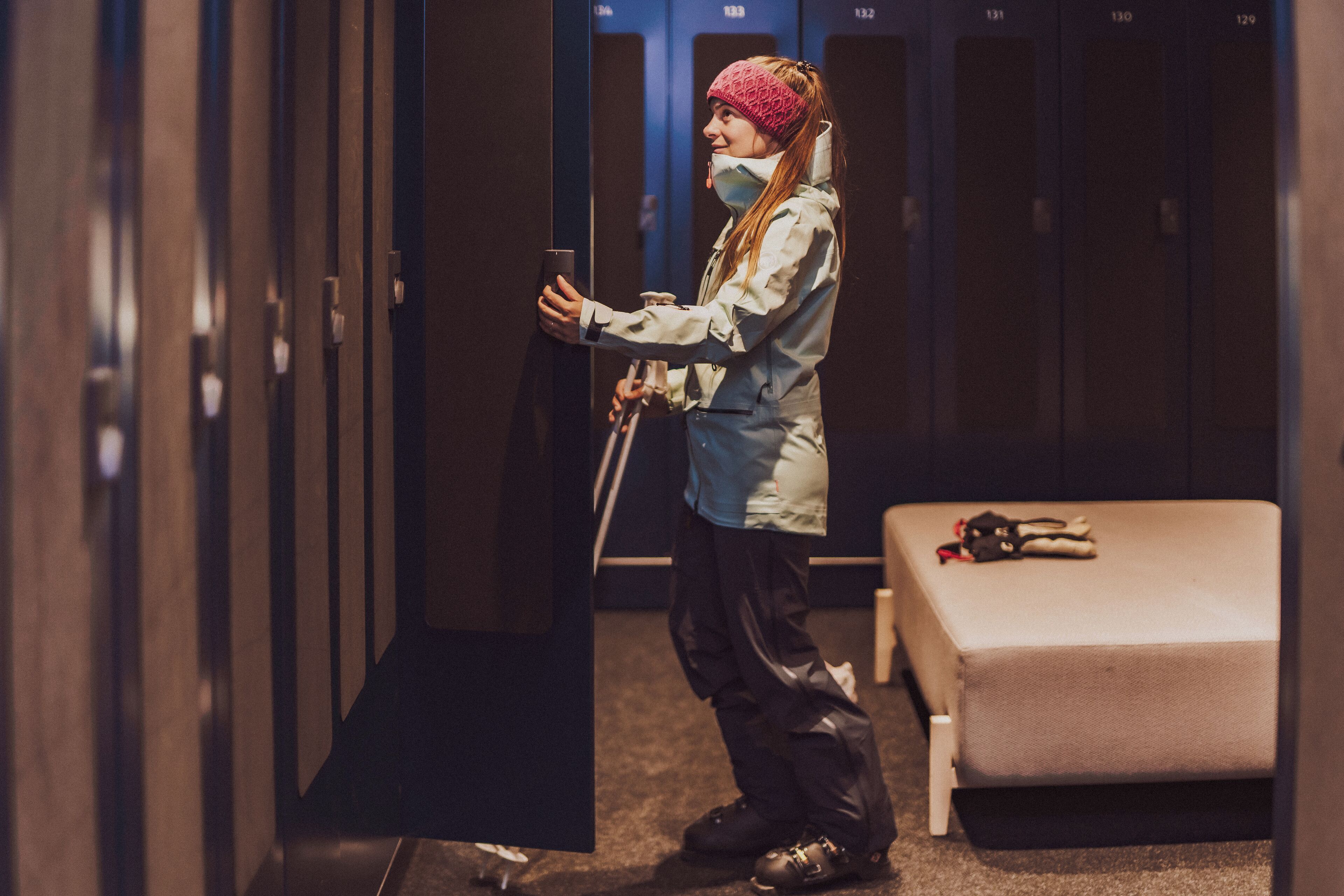 A person in a locker room holding a smartphone.