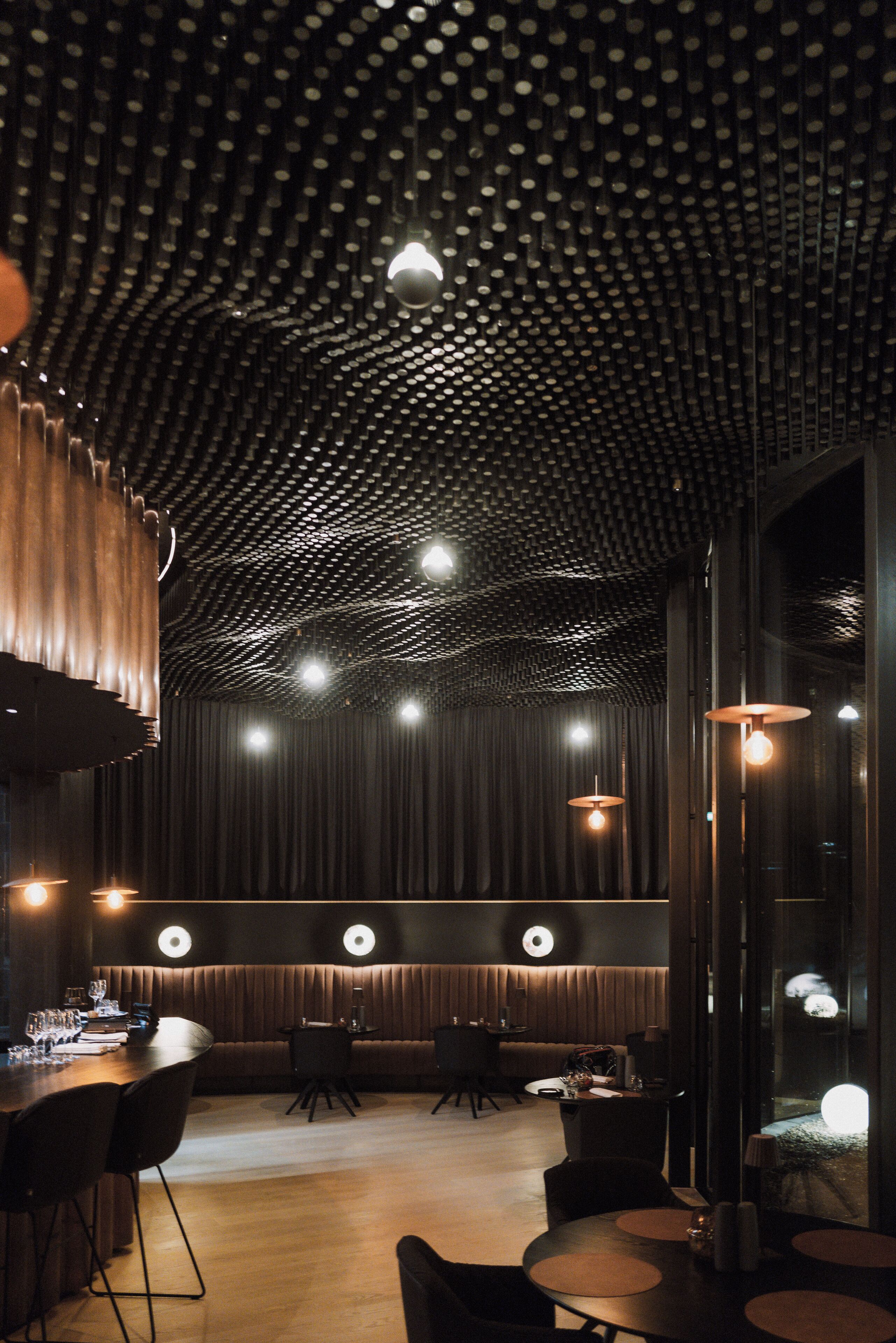 Een modern interieur met een uniek plafondontwerp, sfeerverlichting en een bar.