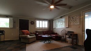 A living room with a fireplace, a ceiling fan, and a large window. - House with fenced  yard, pets welcome, one level,  Supply, NC (Supply)