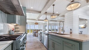 A spacious kitchen with a large island, stainless steel appliances, and pendant lighting.