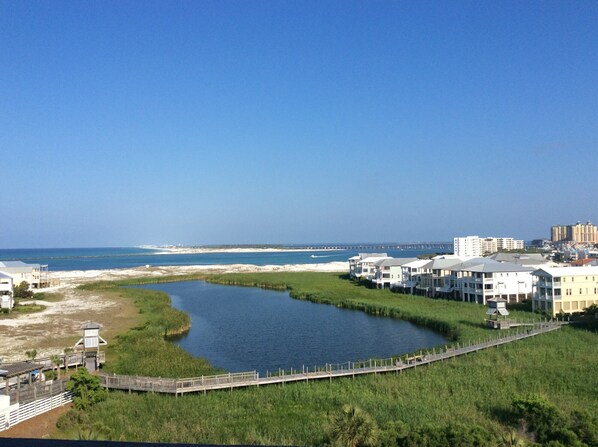 A coastal area with a river, buildings, and a pier.