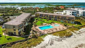 A resort with multiple buildings, a swimming pool, and a beach area. - Direct Beach Front, High End Vacation,Snow Bird Special WINTER 2027 (St. Augustine)
