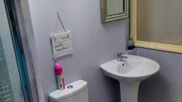 Un baño con inodoro, lavamanos y espejo.