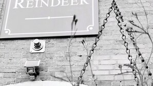 A sign reading "The Reindeer" above a brick wall. - Reindeer Accommodation (Southwell)