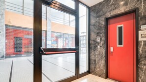A hotel entrance with a red door, a glass door, and a view of the street outside. - GuestHost - The apartment is located on the first floor of a building with a lift, not suitable for the disabled.In 45 square meters of space, it comfortably accommodates 3 people with one bedroom.Located in the Portello district, one of the most histori (Padova)