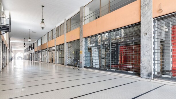 A long corridor with tiled flooring, metal shutters on the right, and hanging lights. - GuestHost - The apartment is located on the first floor of a building with a lift, not suitable for the disabled.In 45 square meters of space, it comfortably accommodates 3 people with one bedroom.Located in the Portello district, one of the most histori (Padova)