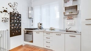 A modern kitchen with white cabinets, a built-in oven, a coffee machine, and a stainless steel range hood. - GuestHost - The apartment is located on the first floor of a building with a lift, not suitable for the disabled.In 45 square meters of space, it comfortably accommodates 3 people with one bedroom.Located in the Portello district, one of the most histori (Padova)