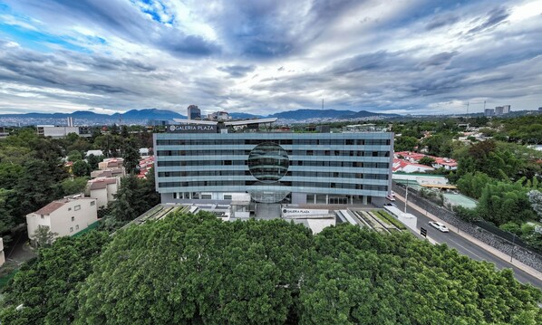Un edificio moderno con una amplia fachada de vidrio y un elemento de diseño circular.