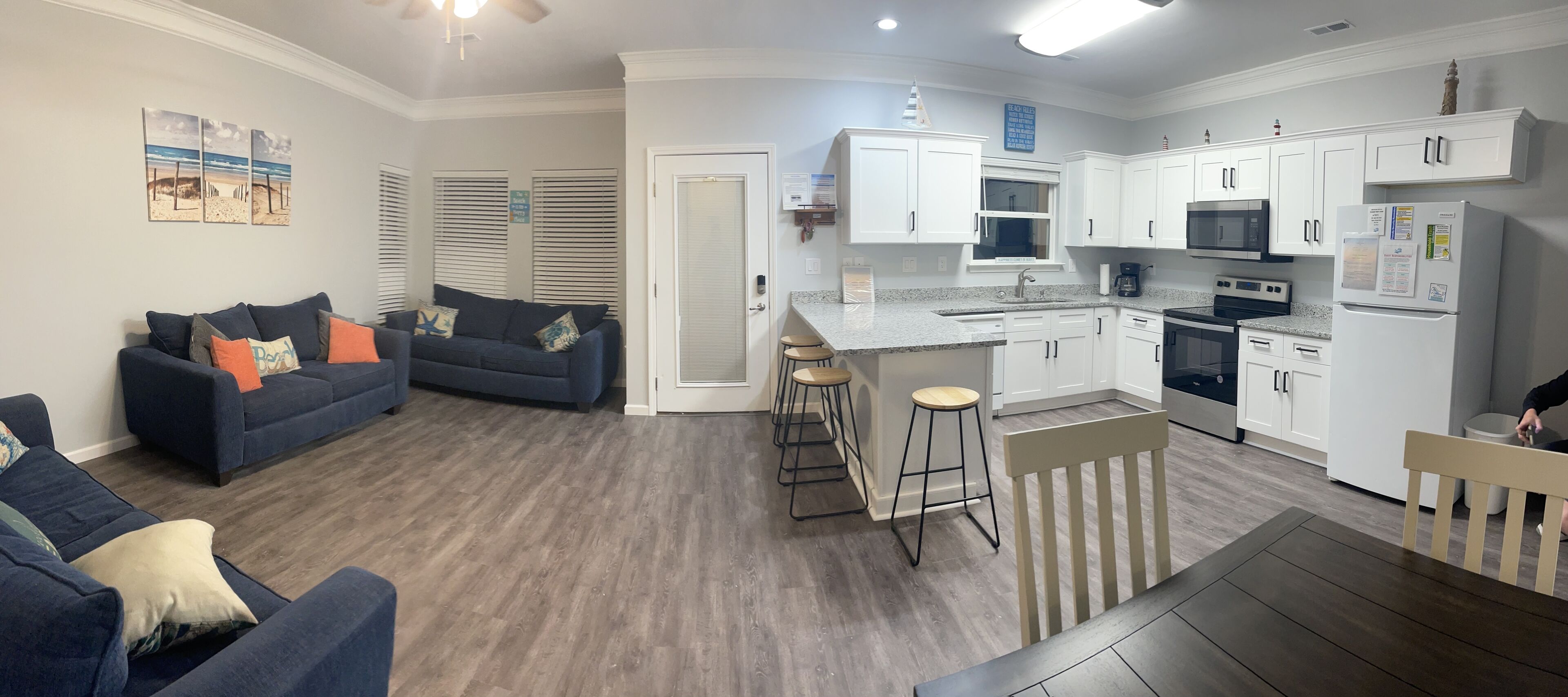 A modern apartment with a living area, kitchen, and dining space.