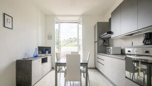Eine moderne Küche mit Essbereich, Blick durch die offene Tür und einem Balkon.