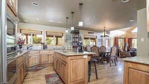 Una cocina amplia con gabinetes de madera, encimeras de granito y una isla central.