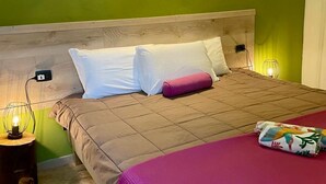A bed with a wooden headboard, white and pink pillows, and a pink blanket. - Bnbook - La Corte di Gallarate (Gallarate)